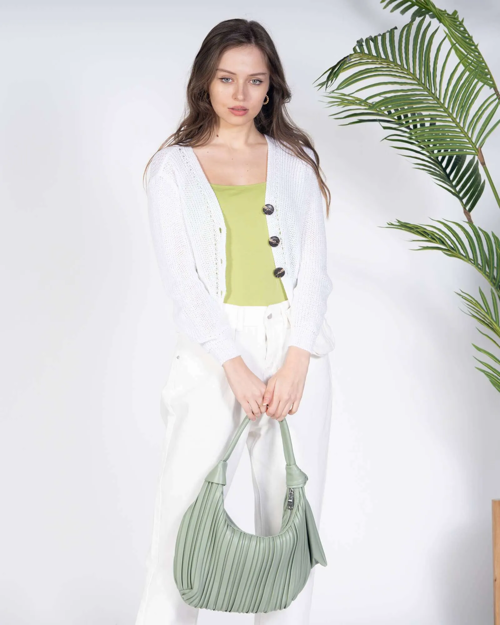 Borsa verde drappeggiata da portare a spalla.